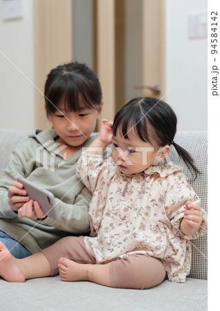 スマホで遊ぶ姉妹の女の子 94584142