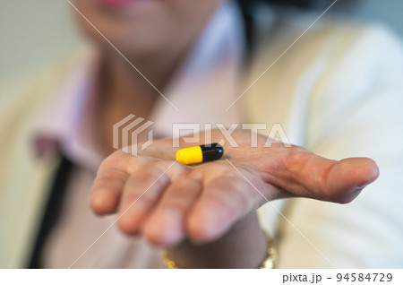 Medicine capsule on a hand 94584729
