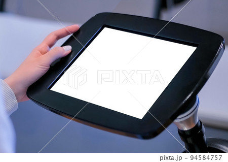 Close up view: woman using floor standing tablet kiosk with blank white display Close up view: woman using floor standing tablet kiosk with blank white display 94584757