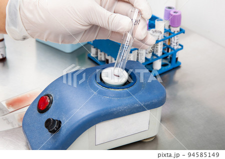 Scientist preparing samples for flow cytometric analysis in the laboratory. Mixing sample using a vortex. Cancer diagnosis 94585149