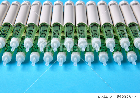 Diabetic insulin pens lined up on a blue background with copy space. Insurance coverage of medicines 94585647