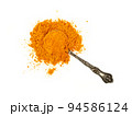 Metal spoon full of yellow turmeric powder 94586124