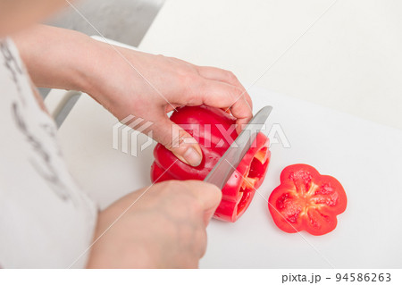 【パプリカ赤色を三徳包丁で輪切りにする】 94586263