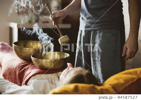 Tibetan singing bowls with smoke in sound therapy in spa center 94587527