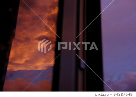 Dawn sky with colorfull clouds. Sunset landscape through the window with reflection on it Dawn sky with colorfull clouds. Sunset landscape through the window with reflection on it 94587649
