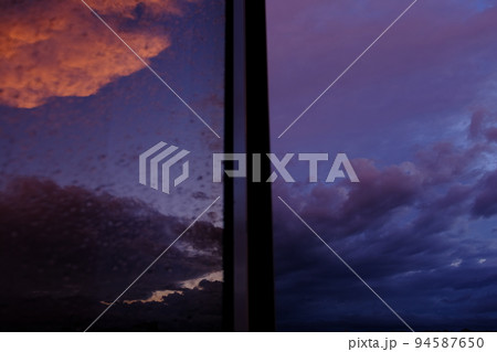 Dawn sky with colorfull clouds. Sunset landscape through the window with reflection on it Dawn sky with colorfull clouds. Sunset landscape through the window with reflection on it 94587650