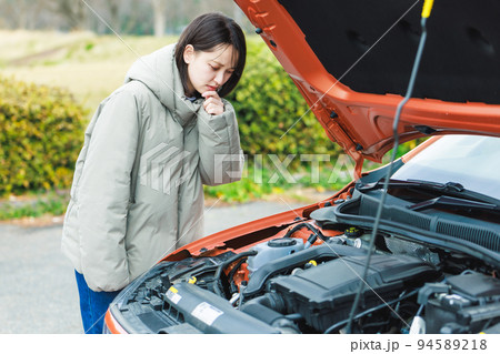 車が故障して困った様子の若い女性ドライバー 車が故障して困った様子の若い女性ドライバー 94589218