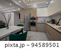 Modern white and beige large luxurious kitchen and dining table in studio apartment 94589501
