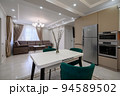 Modern white and beige large luxurious kitchen and dining table in studio apartment 94589502