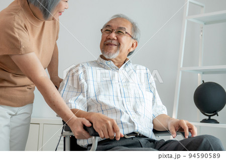 Senior wife giving support to her husband in his wheelchair with love. Senior wife giving support to her husband in his wheelchair with love. 94590589