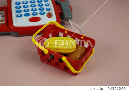 Toy store with food. Children's set with a cash register and products for development. Plastic food and money counting calculator. Toy store with food. Children's set with a cash register and products for development. Plastic food and money counting calculator. 94591266