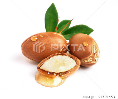 Argan nuts with green leaves on isolated white background. Moroccan Argania Spinosa seeds for the production of oil 94591453