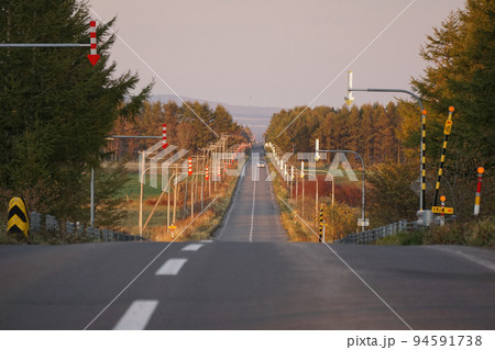 どこまでも真っ直ぐに伸びるアップダウンのある道路 94591738