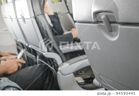 Selective focus on a closed table, a table for food in the cabin, a blurred background of passengers in the background of the interior, the concept of convenient flights and travel 94593445