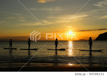 夕暮れの逗子海岸、陽射しを浴びてSUPヨガを楽しむ若者たち 94596231