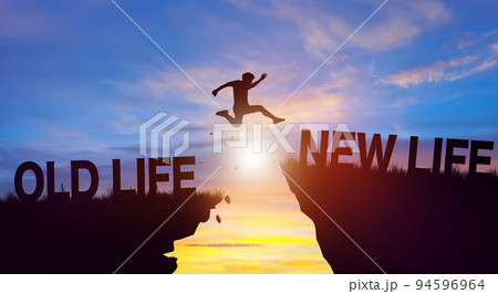 Silhouette man jumping from OLD LIFE to NEW LIFE wording on cliffs with cloud sky and sunrise. Achievement, and Business Concept. Silhouette man jumping from OLD LIFE to NEW LIFE wording on cliffs with cloud sky and sunrise. Achievement, and Business Concept. 94596964