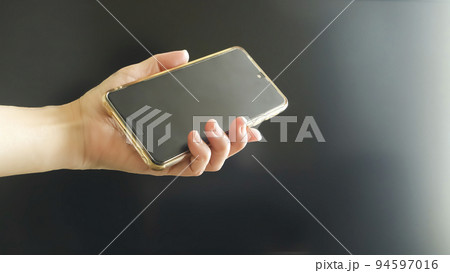 スマホを持つ手 94597016