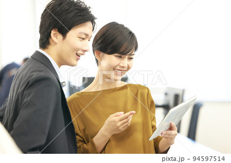 打ち合わせ_タブレットを指さすビジネスウーマン1 打ち合わせ_タブレットを指さすビジネスウーマン1 94597514