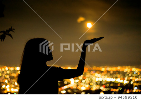silhouette Woman portrait with full moon in city night light bokeh background , Chiang mai ,Thailand 94599510