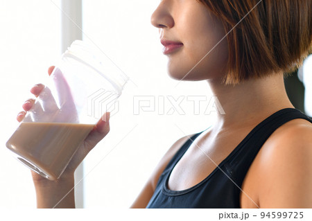 ジムでプロテインを飲む若いアジア人の女性 94599725