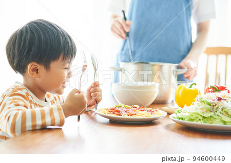 食事の支度をする母親と男の子 94600449
