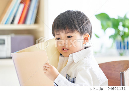 真剣に本を読む低学年の男の子 94601131