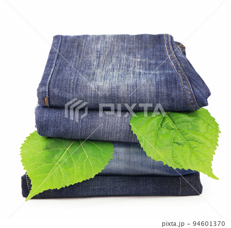 green spring leaves and pile of jeans clothes green spring leaves and pile of jeans clothes 94601370