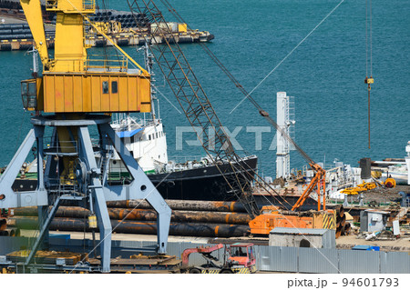 industrial seaport infrastructure, sea, cranes and raw materials, metal structures and ship, the concept of marine cargo transportation 94601793