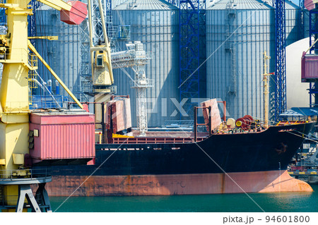 industrial infrastructure of seaport, sea, cranes and dry cargo ship, grain silo, bulk carrier vessel and grain storage elevators, concept of sea cargo transportation industrial infrastructure of seaport, sea, cranes and dry cargo ship, grain silo, bulk carrier vessel and grain storage elevators, concept of sea cargo transportation 94601800