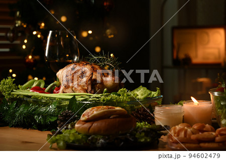 Roasted turkey on Thanksgiving table or Christmas dinner by candlelight in a decorated room with a Christmas tree Roasted turkey on Thanksgiving table or Christmas dinner by candlelight in a decorated room with a Christmas tree 94602479