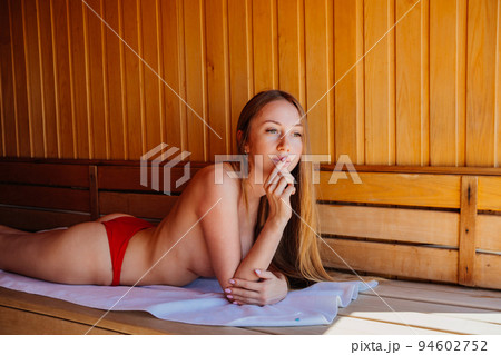 woman topless lies on a bench in the sauna. woman topless lies on a bench in the sauna. 94602752
