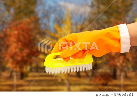 Woman's hand in protective glove with brush. Woman's hand in protective glove with brush. 94603531