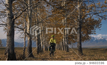 The woman travel on mixed terrain cycle touring with bikepacking. The traveler journey with bicycle bags. Sport tourism bikepacking. The woman travel on mixed terrain cycle touring with bikepacking. The traveler journey with bicycle bags. Sport tourism bikepacking. 94603596
