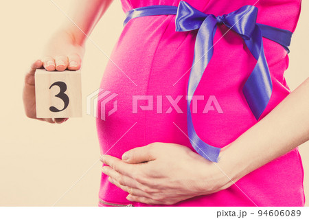 Hand of woman showing number of third month of pregnancy, expecting for newborn concept 94606089