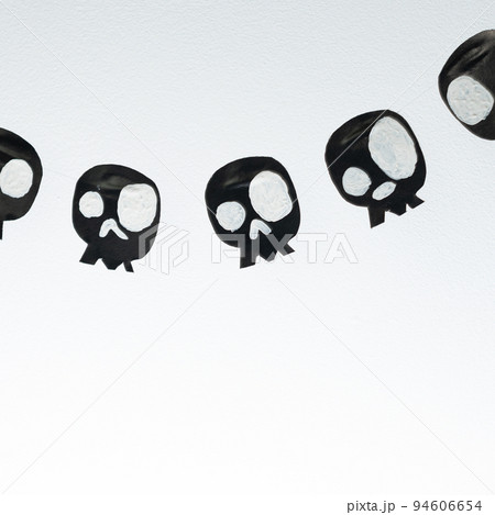 Skulls cut out of black paper on a white background, preparation for Halloween. Skulls cut out of black paper on a white background, preparation for Halloween. 94606654