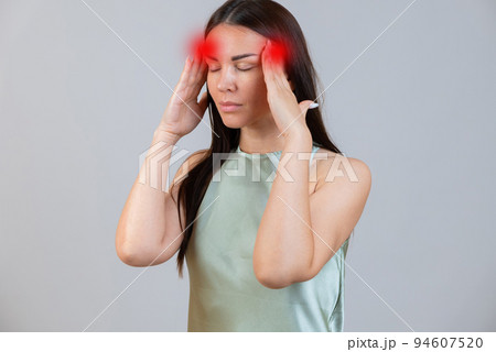 Young beautiful woman has headache, isolated on gray background. Exhausted girl portrait Young beautiful woman has headache, isolated on gray background. Exhausted girl portrait 94607520