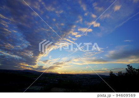 秋の夕焼け・広がるうろこ雲と飛行機雲・日没後 94609569