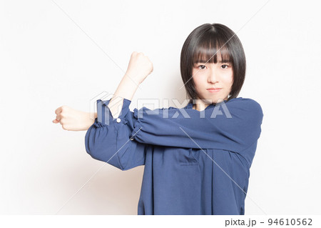 白背景の前でストレッチしている若い女性 白背景の前でストレッチしている若い女性 94610562
