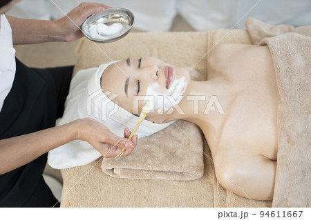 泡を使うフェイシャルエステを受ける女性 94611667