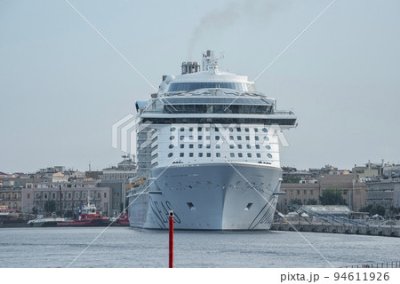 Messina, Sicily, Italy. August 26, 2022. Majestic cruise ship moored at harbor. Luxurious nautical vessel at Mediterranean port in ancient city of Messina with blue sky in background. 94611926