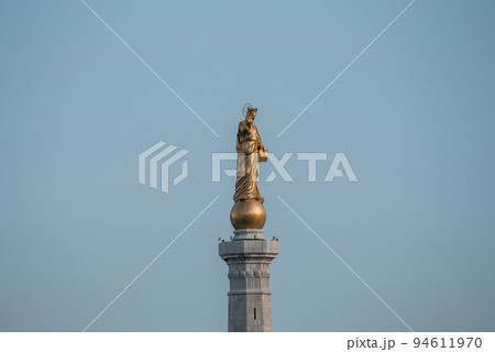 Messina, Sicily, Italy. August 26, 2022. Low angle close-up view of beautiful Statue of Golden Madonna. Famous religious female sculpture monument at Messina port with blue sky in background. 94611970