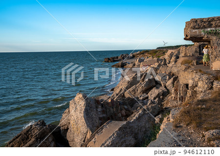 Ruins of bunkers on the beach of the Baltic sea, part of an old fort in the former Soviet base Karosta in Liepaja, Latvia. Sunset landscape. 94612110