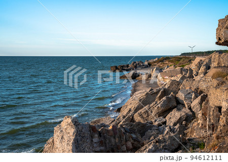 Ruins of bunkers on the beach of the Baltic sea, part of an old fort in the former Soviet base Karosta in Liepaja, Latvia. Sunset landscape. 94612111