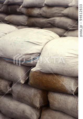 Background of many dirty sand bags for flood defense. Protective sandbag barricade for military use. Handsome tactical bunker 94612633