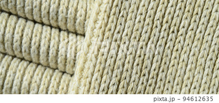 Composition of a soft yellow knitted sweater. Macro texture of bindings in yarns Composition of a soft yellow knitted sweater. Macro texture of bindings in yarns 94612635
