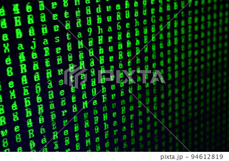 Macro shot of a glitch on the monitor of an office computer. The concept of introducing a virus into a personal data keeper. Stream of random green symbols on a black background 94612819