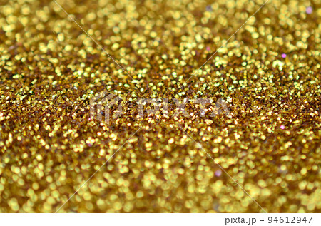 A huge amount of yellow decorative sequins. Background texture with shiny, small elements that reflect light in a random order. Glitter texture 94612947