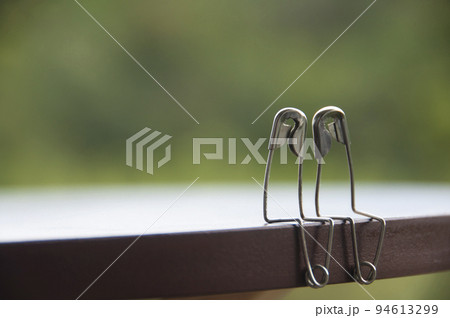 Safety pin couple sitting on table with customizable space for text and ideas. Love and romance concept 94613299