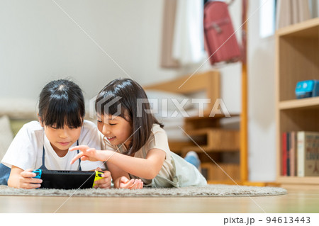 ゲームを一緒にする小学生の女の子 94613443