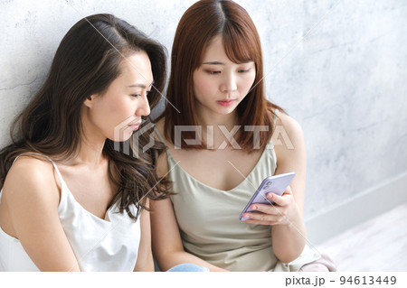 スマホを一緒に見ている女性二人 スマホを一緒に見ている女性二人 94613449